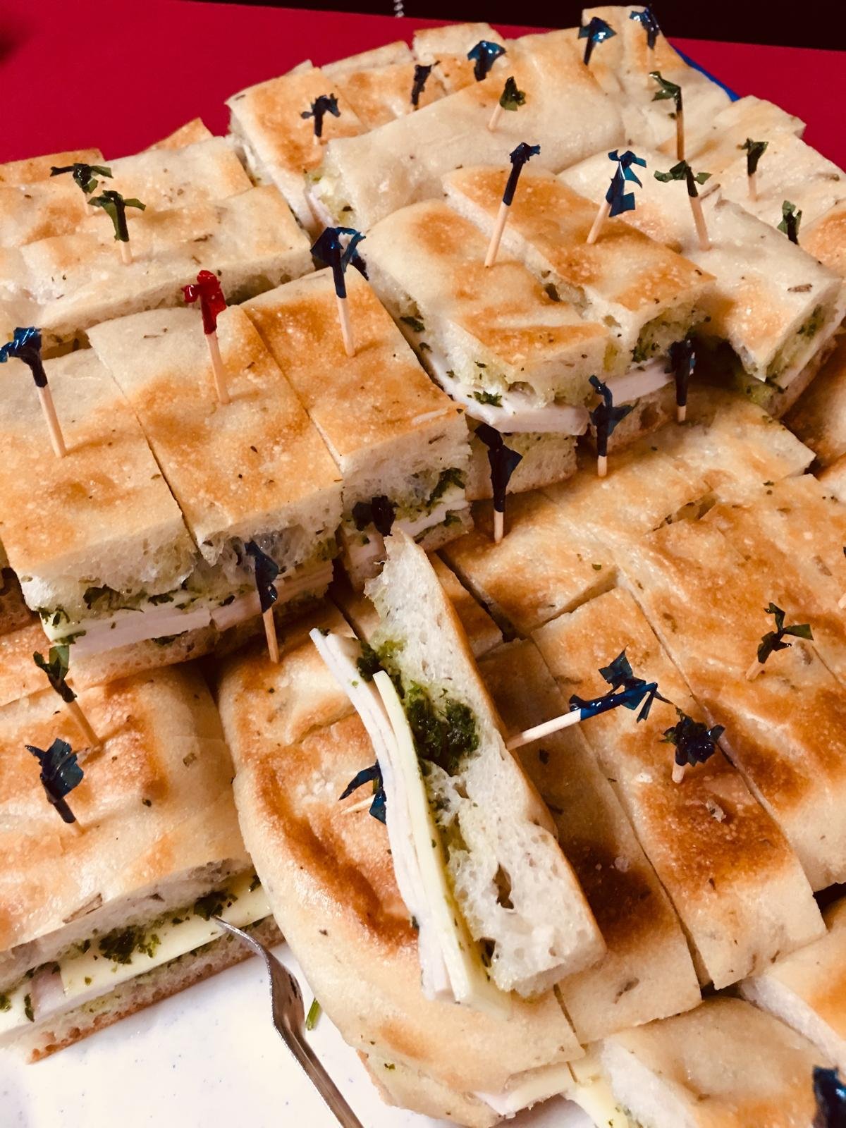 Pressed flatbread sandwiches cut into squares.