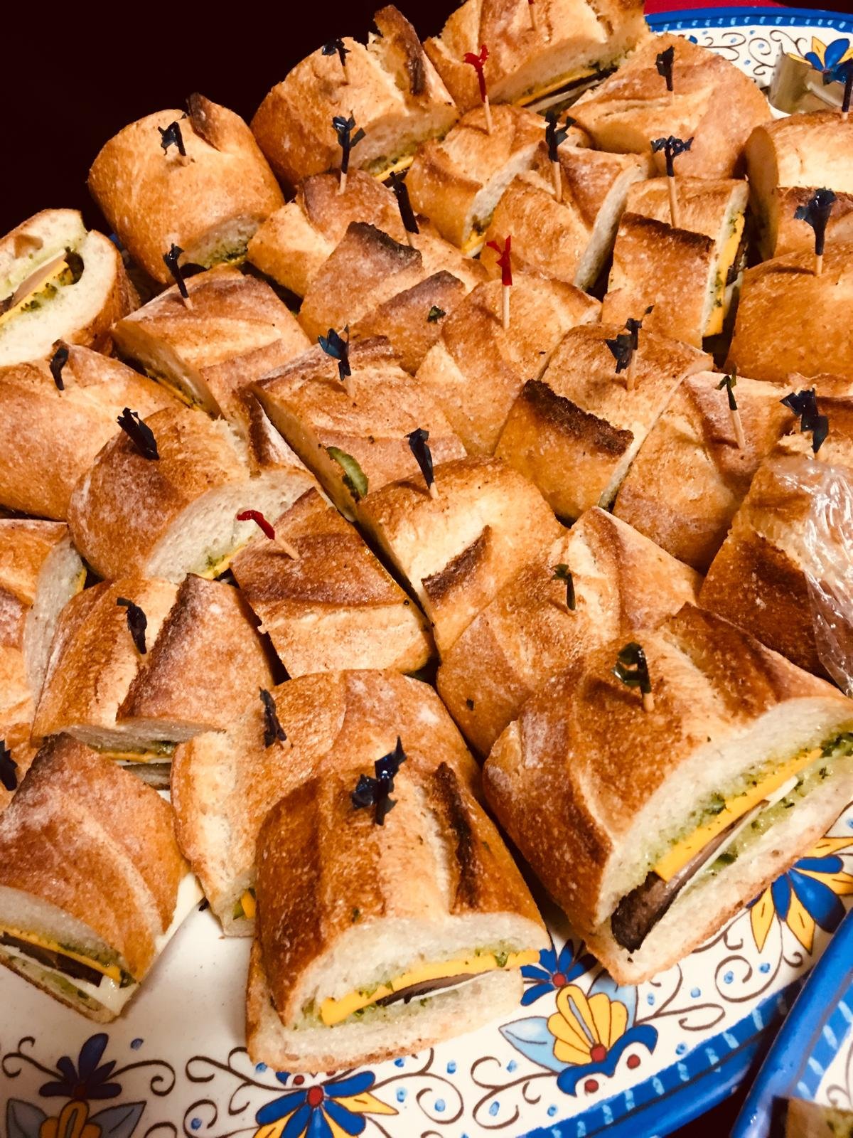 Toasted sandwich squares piled on a patterned platter.