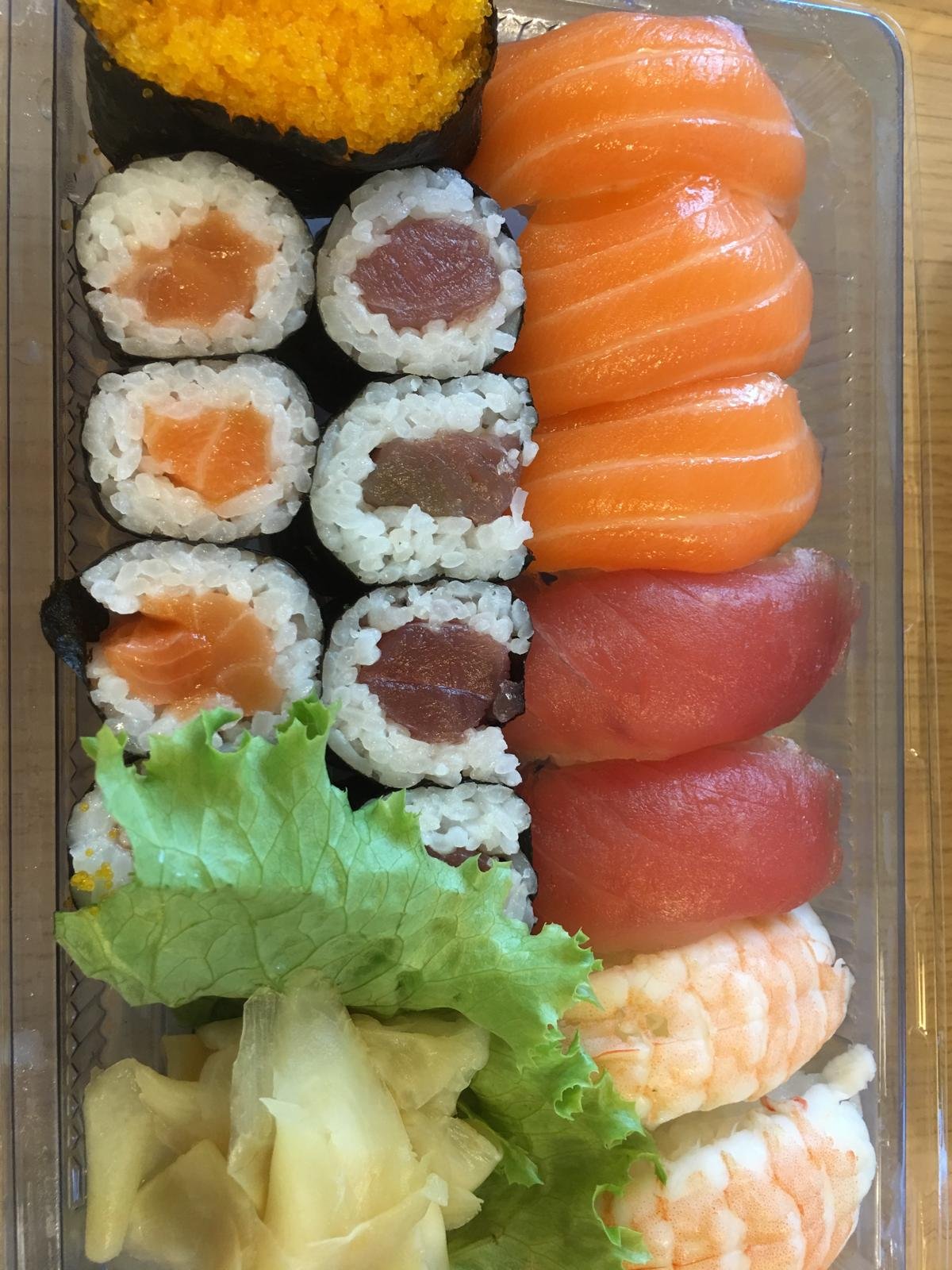 Sushi rolls and nigiri in a tray with lettuce.