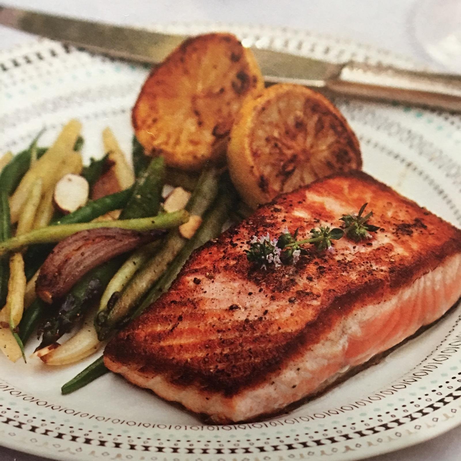 Seared salmon with green beans and roasted lemon.